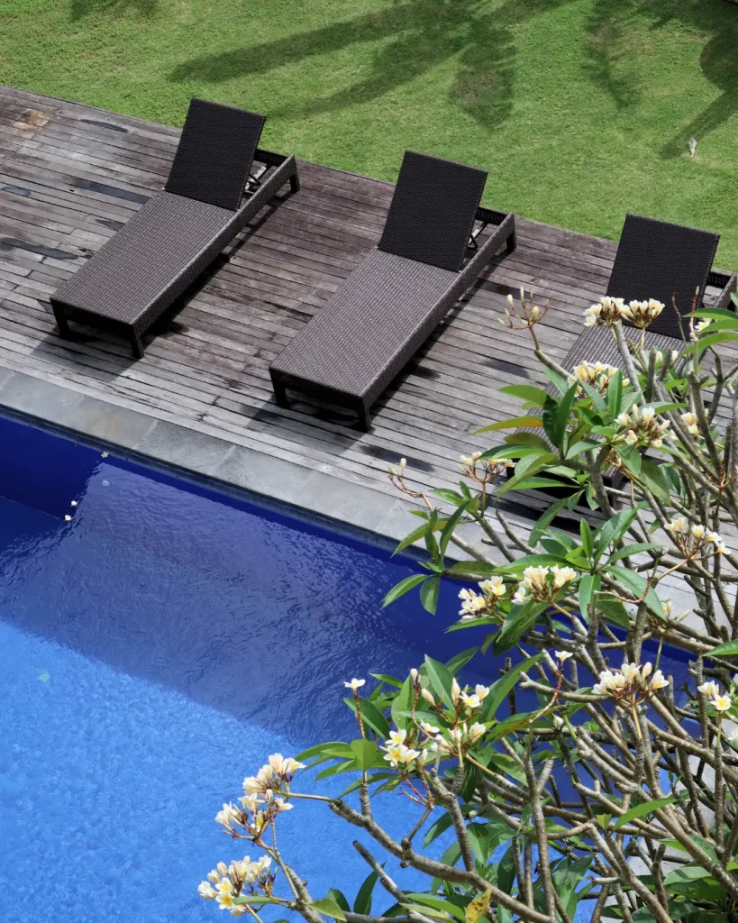 Poolside loungers at Puri Canggu with tropical frangipani