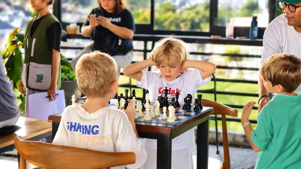 Three kids deep in a game of chess on the rooftop