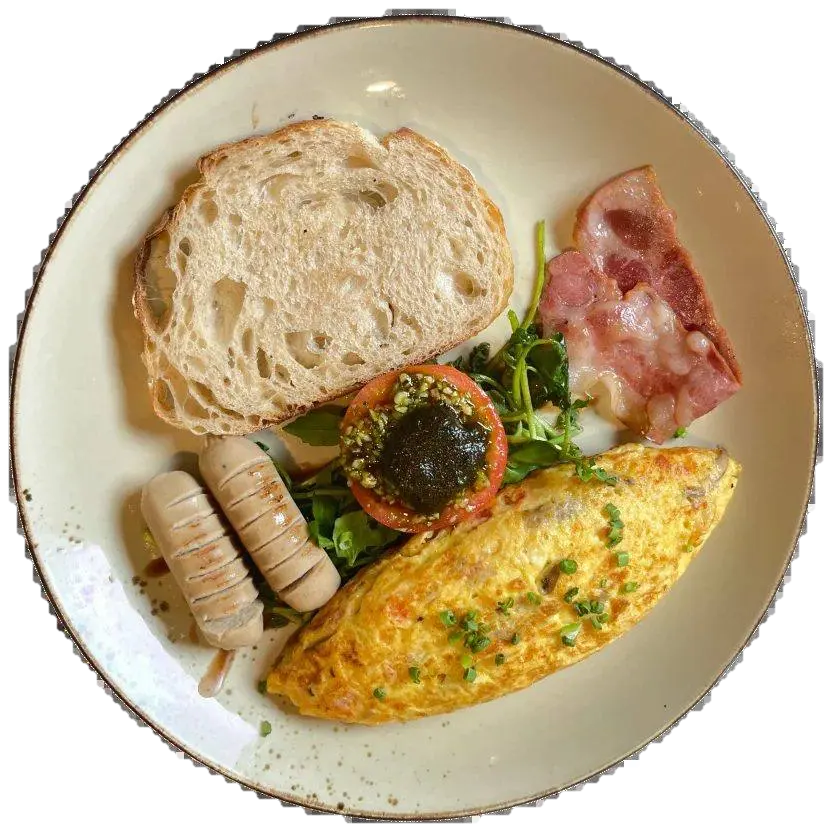 Mix omelette with sourdough, bacon, sausages and grilled tomato