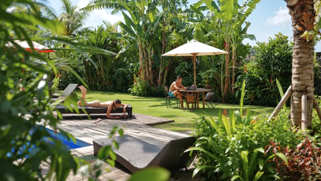 Working at a garden table while a friend sunbathes by the pool
