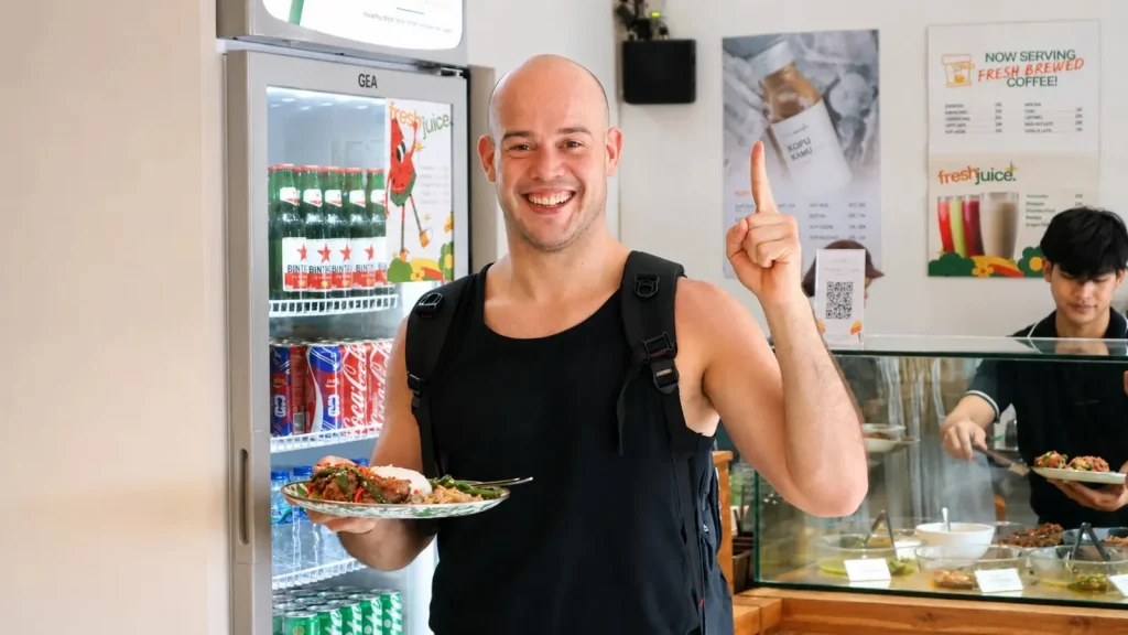 A smiling guest with his plate at the counter