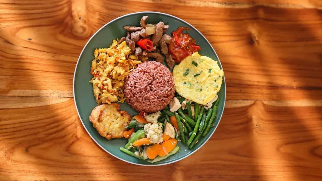 Red rice with beef, vegetables and sambal
