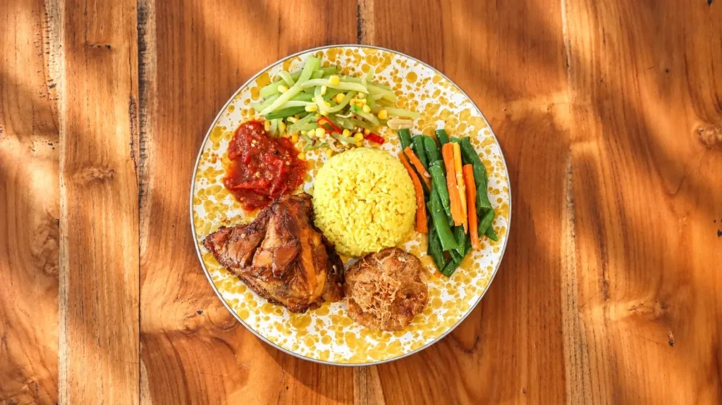 Yellow rice with grilled chicken, sambal and vegetables